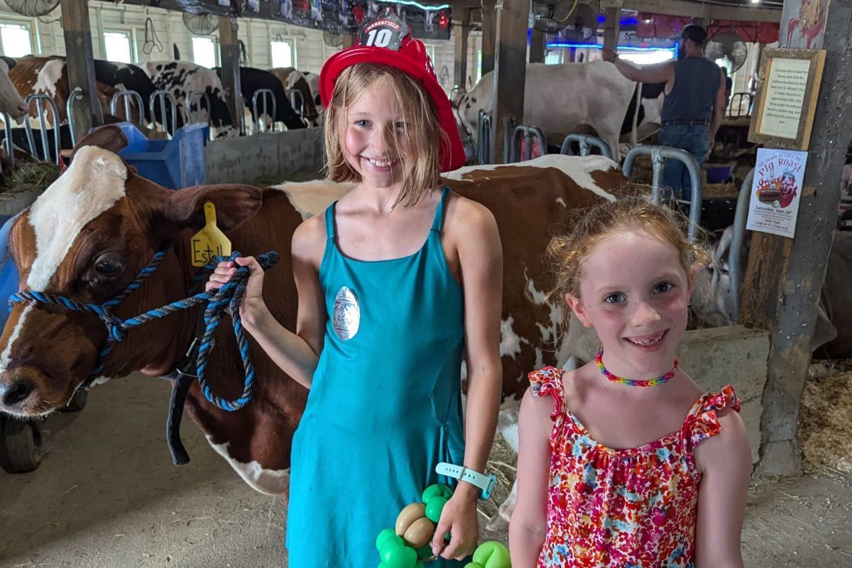 Check out some of central Wisconsinโs best festivals & summer events | Two girls posing with a cow at the Central Wisconsin State Fair in Marshfield